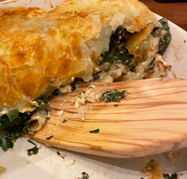 Baked spanakopita sliced with golden brown puff pastry.