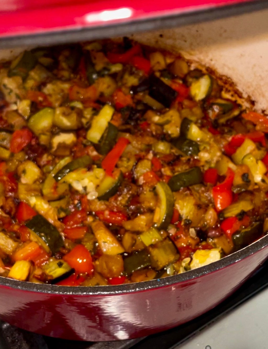 Caponata made with small pieces of vegetables cooked in a large Dutch oven with olive oil and spices.
