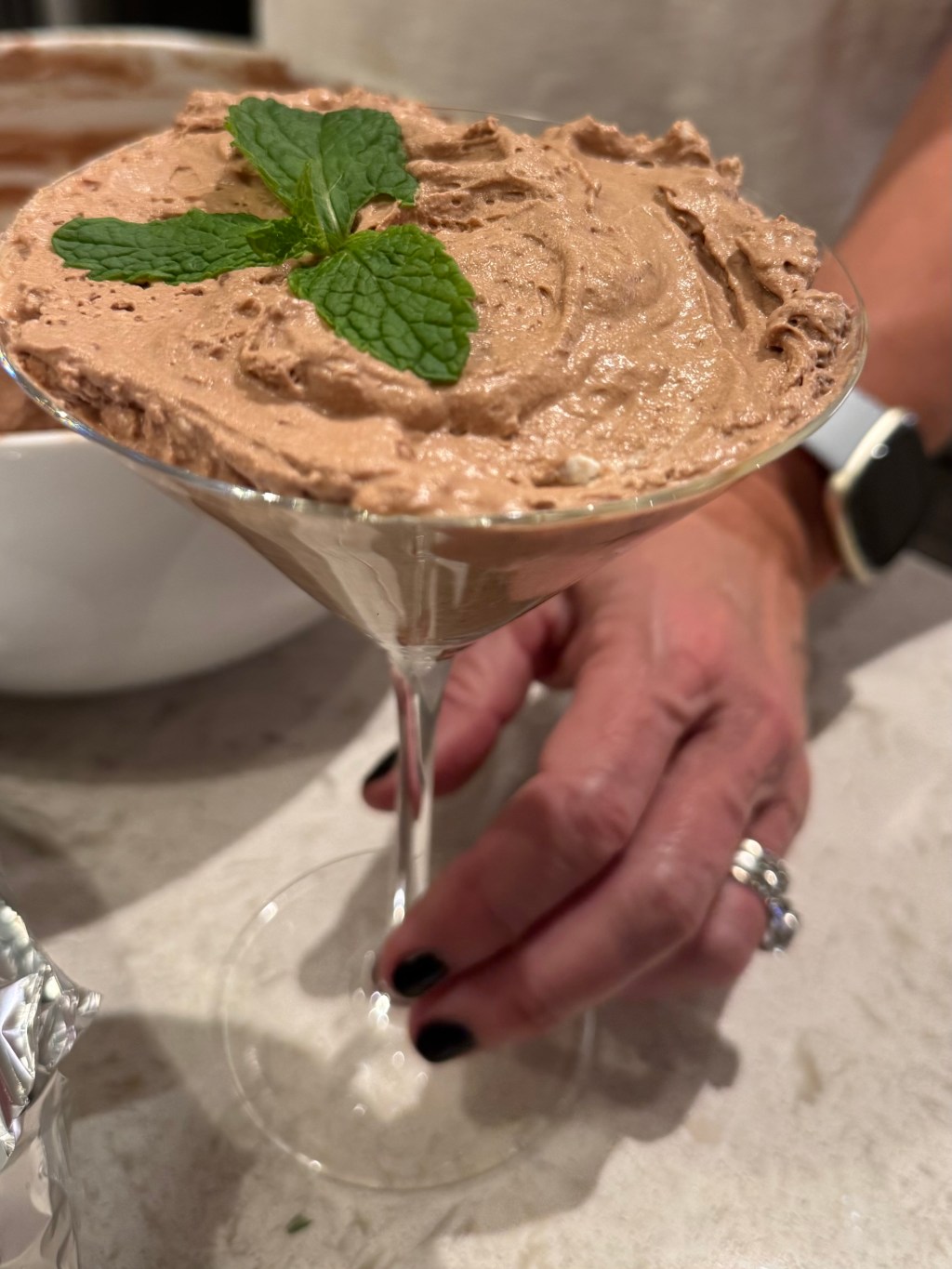 chocolate mousse with mint on top in a martini glass.